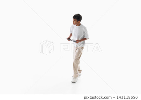 Young man walking and checking smartphone on minimal white background Young man walking and checking smartphone on minimal white background 143119650