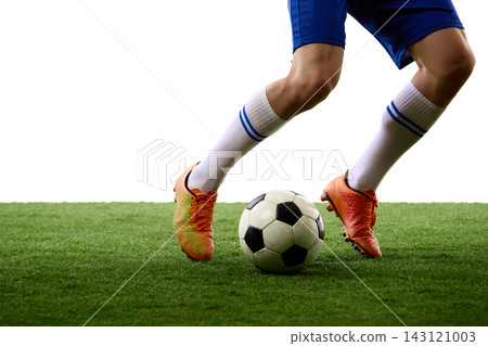 Closeup of soccer boots guiding ball across green turf Closeup of soccer boots guiding ball across green turf 143121003