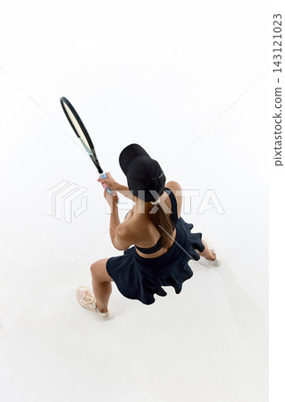 Top view of female tennis player preparing two handed backhand in low lunge. Top view of female tennis player preparing two handed backhand in low lunge. 143121023