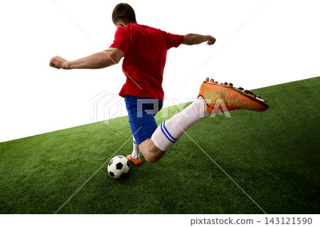 Rear view of teen footballer striking ball with extended leg Rear view of teen footballer striking ball with extended leg 143121590