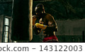 Dedicated fighter practices close-range punches on a heavy bag with relentless energy Dedicated fighter practices close-range punches on a heavy bag with relentless energy 143122003