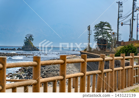 觀光列車「貝爾蒙特」沿著天晴海岸行駛，以富山灣的恩納岩和立山山脈為背景。 143122139