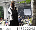 A scene from a festival: a woman holding a camera. 143122248