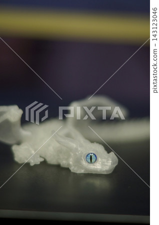 A small pale animal-shaped figurine lies on a dark tabletop in shallow focus against a blurred background. The image represents fragility, solitude, imagination, and the emotional storytelling A small pale animal-shaped figurine lies on a dark tabletop in shallow focus against a blurred background. The image represents fragility, solitude, imagination, and the emotional storytelling 143123046