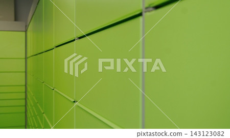 Close view of a long wall of bright green storage lockers with repeating doors and metal dividers. The image represents order, security, and efficient use of space in an automated storage system. Close view of a long wall of bright green storage lockers with repeating doors and metal dividers. The image represents order, security, and efficient use of space in an automated storage system. 143123082