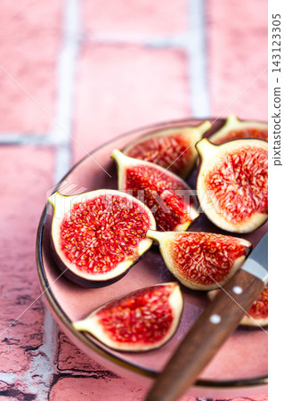 Close-up of bright, fresh, ripe figs on plate, pink stone background Close-up of bright, fresh, ripe figs on plate, pink stone background 143123305