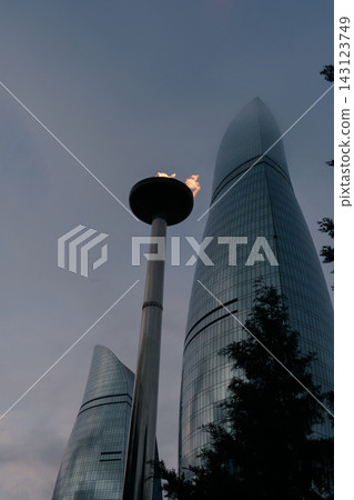 Baku Flame Towers stand tall with a flame at sunset illuminating the skyline of Baku city 143123749