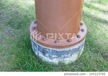 Bolted flange base of steel post on concrete foundation Bolted flange base of steel post on concrete foundation 143123795