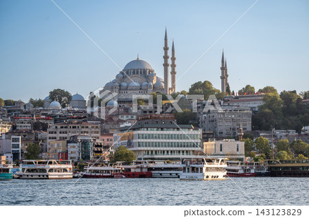 Istanbul,turkey,august 4, 2025. Istanbul's historic suleymaniye mosque and surrounding buildings rise above the bosphorus, with tour boats navigating the waterway 143123829