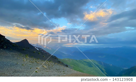 Sunset colors dense clouds, wide view above layered ridges and alpine slopes in Svaneti, Georgia, documenting evening weather Sunset colors dense clouds, wide view above layered ridges and alpine slopes in Svaneti, Georgia, documenting evening weather 143123908