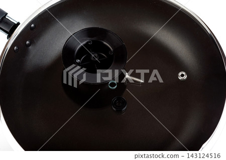 Close Up of Unassembled Frying Pan Lid Handle Components and Screw Inside the Pan Close Up of Unassembled Frying Pan Lid Handle Components and Screw Inside the Pan 143124516