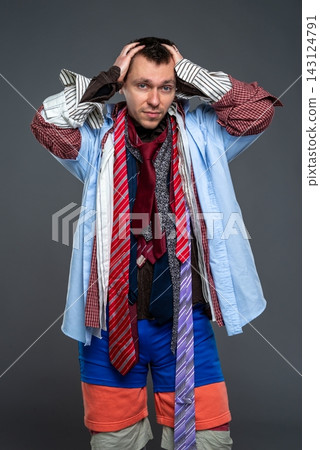 Stressed man in multiple layers of clothing holding his head Stressed man in multiple layers of clothing holding his head 143124791