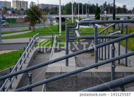 Metal handrails with cracked paint along public concrete accessibility ramps providing barrier free environment in city Metal handrails with cracked paint along public concrete accessibility ramps providing barrier free environment in city 143125587