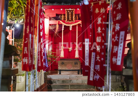 夜幕降臨,王子聖族稻荷神社外牆上掛滿了紅色的布條。 夜幕降臨,王子聖族稻荷神社外牆上掛滿了紅色的布條。 143127803