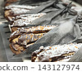 A display of sweets covered in chocolate and powdered sugar. 143127974