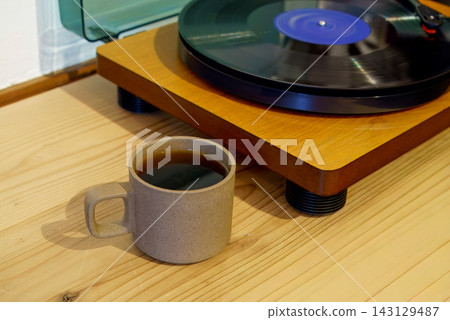 Enjoying records and coffee at a wooden table Enjoying records and coffee at a wooden table 143129487