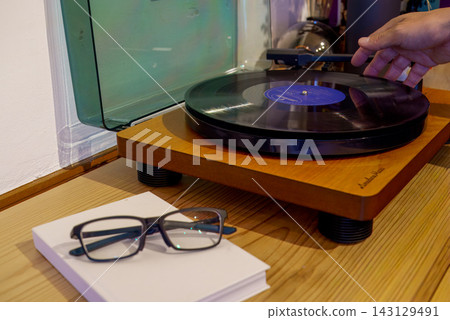 The hands of the person playing the analog record The hands of the person playing the analog record 143129491