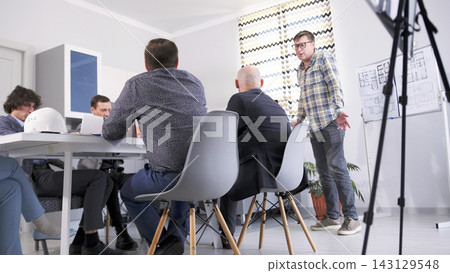 The contractor of the construction company reports to the management at a meeting in the conference room. A group of people is sitting at a table The contractor of the construction company reports to the management at a meeting in the conference room. A group of people is sitting at a table 143129548