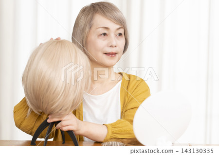 有些老年婦女因為擔心頭髮稀疏而戴假髮。 有些老年婦女因為擔心頭髮稀疏而戴假髮。 143130335