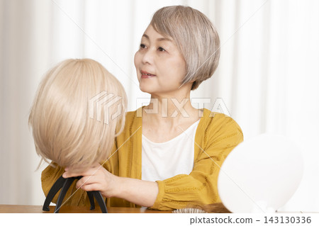 有些老年婦女因為擔心頭髮稀疏而戴假髮。 有些老年婦女因為擔心頭髮稀疏而戴假髮。 143130336