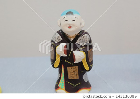 A traditional Kyoto craft, the Fushimi doll "Manju-kui" (eating a sweet bun), is a local toy that symbolizes filial piety and wisdom. A traditional Kyoto craft, the Fushimi doll "Manju-kui" (eating a sweet bun), is a local toy that symbolizes filial piety and wisdom. 143130399