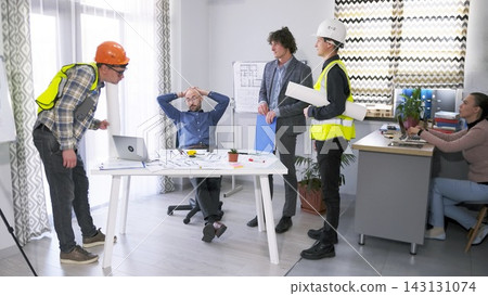 Approval of the project budget. Two construction workers and a manager gathered at the chief architect's desk in the conference room Approval of the project budget. Two construction workers and a manager gathered at the chief architect's desk in the conference room 143131074