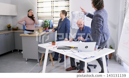 A group of colleagues gathered around a table in the conference room to discuss the details of the project. The secretary is on the phone A group of colleagues gathered around a table in the conference room to discuss the details of the project. The secretary is on the phone 143131139