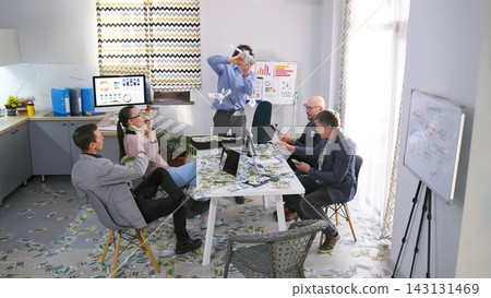 A team of happy businessmen is sitting at the negotiating table and rejoicing at a successful deal. People count money in the office A team of happy businessmen is sitting at the negotiating table and rejoicing at a successful deal. People count money in the office 143131469