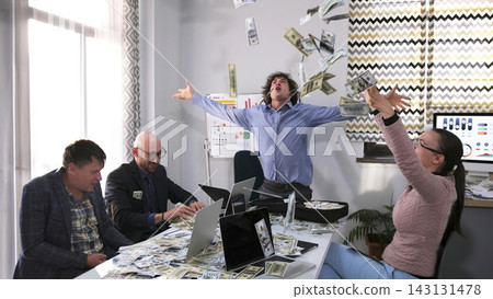 A man throws money in the air, and other people look at it. The action takes place in a conference room where a group of people A man throws money in the air, and other people look at it. The action takes place in a conference room where a group of people 143131478