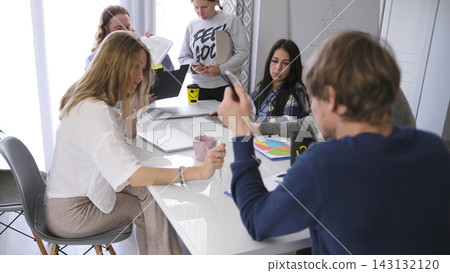 A group of businessmen and businesswomen in informal clothes gathered for a meeting. Working on a startup. Brainstorming A group of businessmen and businesswomen in informal clothes gathered for a meeting. Working on a startup. Brainstorming 143132120