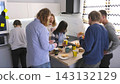 Business lunch. Coffee break. A creative group of young developers came to the office kitchen to have lunch and chat. A break at work 143132129