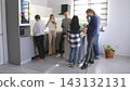 Office workers in informal clothes are chatting casually in the office kitchen. They drink coffee and dream of a better future 143132131