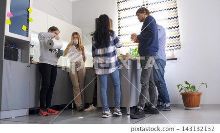 Friends drink tea or coffee standing in a cozy kitchen. Business lunch. Coffee break. A legitimate break from work Friends drink tea or coffee standing in a cozy kitchen. Business lunch. Coffee break. A legitimate break from work 143132132