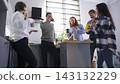 Tired office workers drink coffee and eat sandwiches standing in the cozy office kitchen. Business lunch. Lunch break 143132229