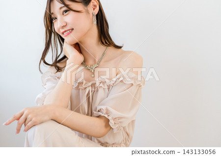 一位佩戴項鍊和耳環的迷人女子。展現優雅珠寶和時尚的畫面。 143133056