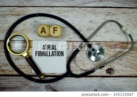 Atrial Fibrillation (AF) text with stethoscope and magnifying glass on wooden background Atrial Fibrillation (AF) text with stethoscope and magnifying glass on wooden background 143133087