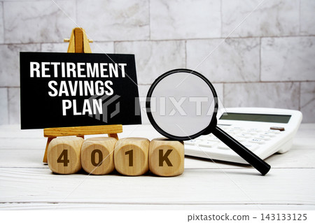 401(k) Retirement Savings Plan text with calculator magnifying glass and on wooden background 401(k) Retirement Savings Plan text with calculator magnifying glass and on wooden background 143133125