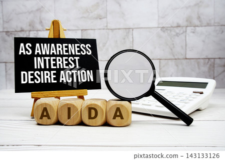 AIDA As Awareness Interest Desire Action text with calculator magnifying glass and on wooden background AIDA As Awareness Interest Desire Action text with calculator magnifying glass and on wooden background 143133126