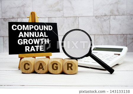 CAGR Compound Annual Growth Rate text with calculator magnifying glass and on wooden background CAGR Compound Annual Growth Rate text with calculator magnifying glass and on wooden background 143133138