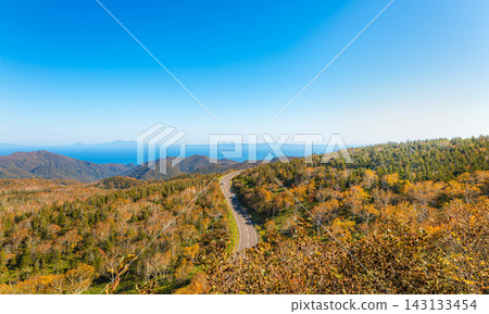 A view from Shiretoko Pass overlooking a calm autumn blue sky, colorful foliage, and the Northern Territories. A view from Shiretoko Pass overlooking a calm autumn blue sky, colorful foliage, and the Northern Territories. 143133454