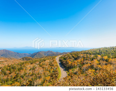 A view from Shiretoko Pass overlooking a calm autumn blue sky, colorful foliage, and the Northern Territories. A view from Shiretoko Pass overlooking a calm autumn blue sky, colorful foliage, and the Northern Territories. 143133456