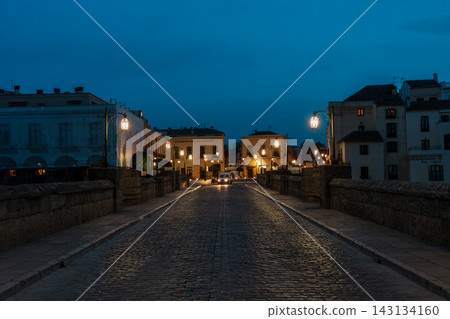 Symmetrical view down the cobblestone Puente Nuevo bridge at blue hour in Ronda, Spain Symmetrical view down the cobblestone Puente Nuevo bridge at blue hour in Ronda, Spain 143134160