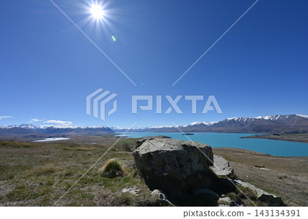 Large rocks and mountain scenery along the shores of Lake Tekapo in New Zealand Large rocks and mountain scenery along the shores of Lake Tekapo in New Zealand 143134391