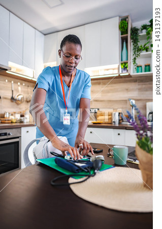 Black nurse packing medical equipment for home care visit Black nurse packing medical equipment for home care visit 143137193