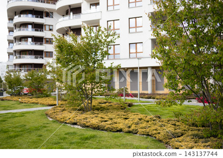 Modern apartment building or resort hotel with beautiful green lawn landscaping. Modern apartment building or resort hotel with beautiful green lawn landscaping. 143137744