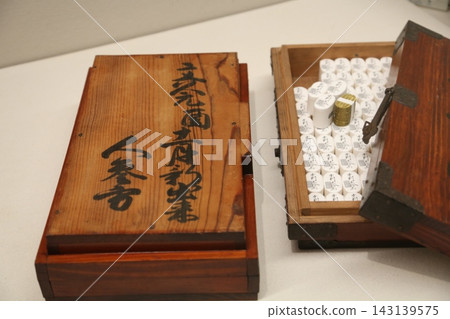 A full view of the replica of the gold coin box and gold coins, inscribed with the characters for "1,000 gold coins," displayed in a historical museum. (Image 3) 143139575