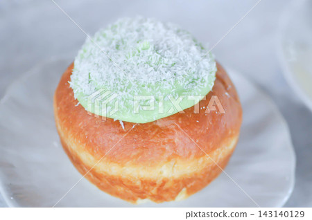 brioche donut or doughnut or bun with green tea dressing or pandan custard and Coconut flakes topping brioche donut or doughnut or bun with green tea dressing or pandan custard and Coconut flakes topping 143140129