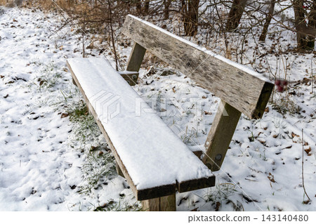 Close up of snow covered park bench in winter. Close up of snow covered park bench in winter. 143140480