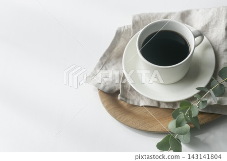 盛在木托盤上的黑咖啡,配上尤加利葉和亞麻布。 盛在木托盤上的黑咖啡,配上尤加利葉和亞麻布。 143141804