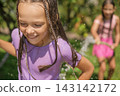 Close up portrait of a happy, laughing girl in splashes of water 143142172